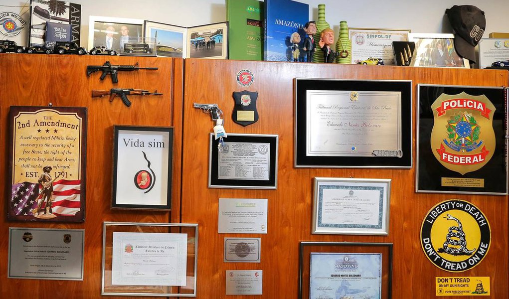 Escritório do filho de Bolsonaro tem altar para armas (Foto: SÉRGIO LIMA/BLOOMBERG) Escritório do filho de Bolsonaro tem altar para armas