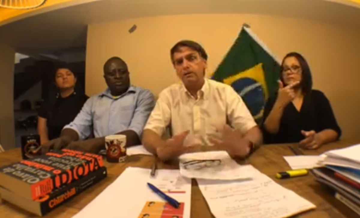 Bandeira do Brasil cai de cenário durante vídeo de Bolsonaro Bandeira do Brasil cai de cenário durante vídeo de Bolsonaro