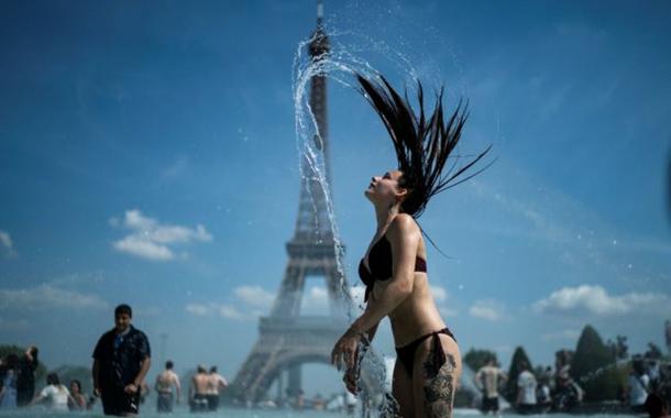 Mulher se banha em frente à Torre Eiffel em dia de calor forte Mulher se banha em frente à Torre Eiffel em dia de calor forte