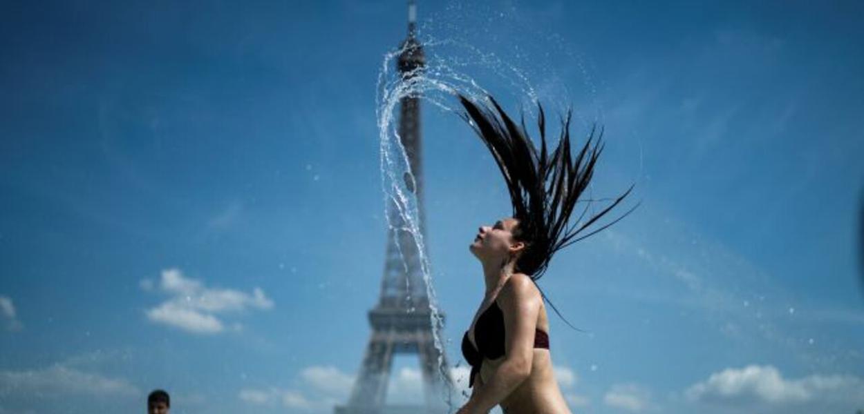 Mulher se banha em frente à Torre Eiffel em dia de calor forte Mulher se banha em frente à Torre Eiffel em dia de calor forte