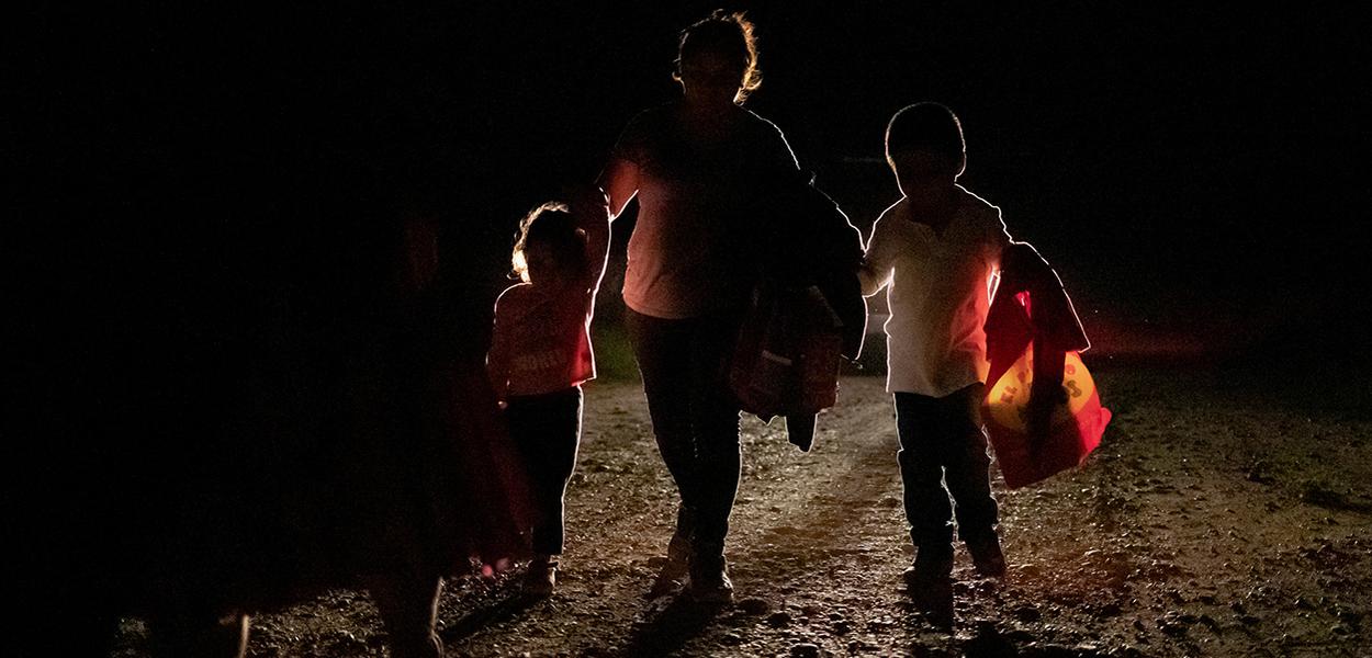 Mulher de Honduras com dois filhos é acompanhada por agente de fronteira dos EUA (Foto: REUTERS/Adrees Latif) Mulher de Honduras com dois filhos é acompanhada por agente de fronteira dos EUA