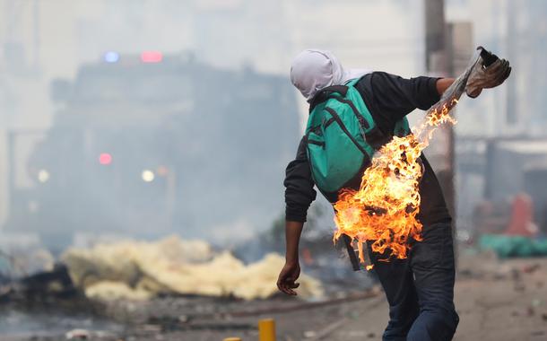 Com um coquetel Molotov, manifestante protesta contra o governo do Equador (Foto: Ivan Alvarado/Reuters) Com um coquetel Molotov, manifestante protesta contra o governo do Equador