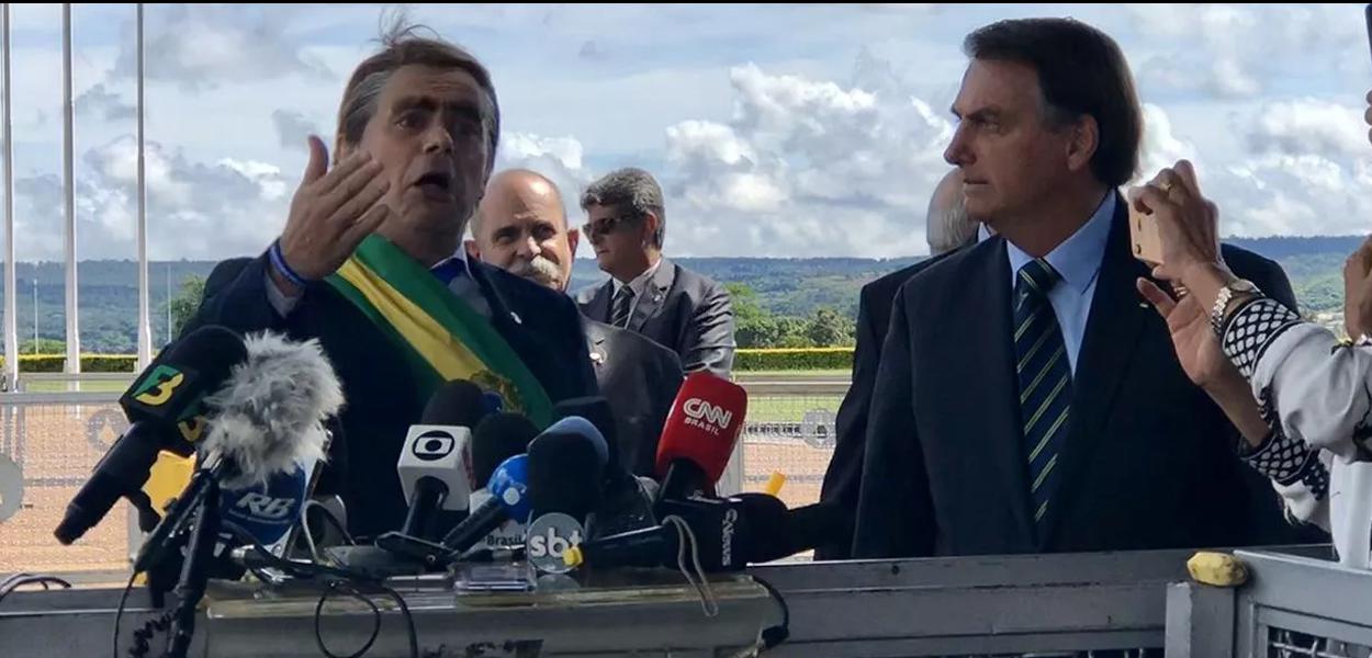 Bolsonaro leva humorista para coletiva do PIB para dar bananas aos jornalistas. (Foto: Reprodução) www.brasil247.com - Bolsonaro leva humorista para coletiva do PIB para dar bananas aos jornalistas.