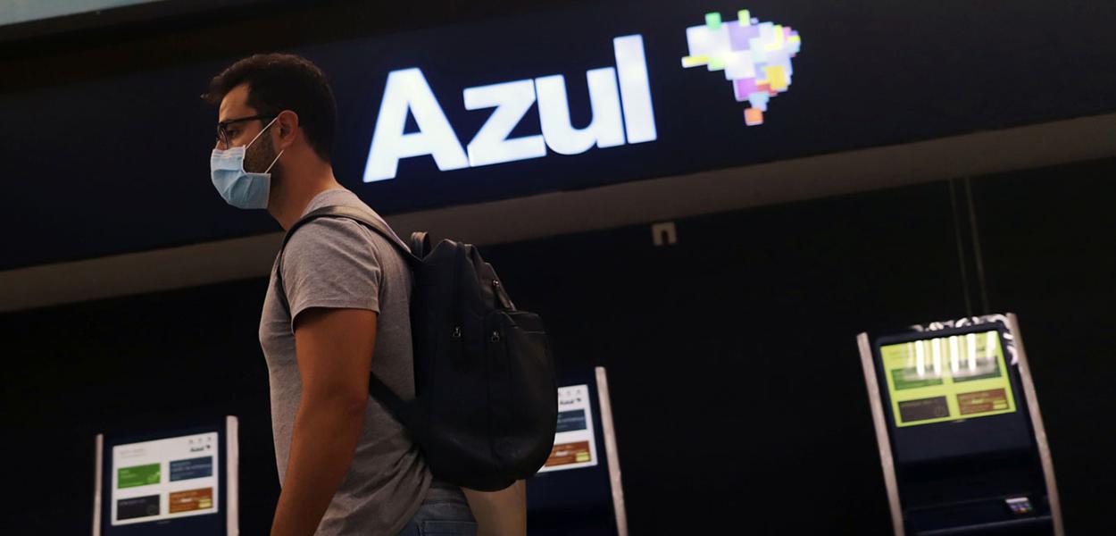Passageiros usam máscara em frente a galpão da Azul: setor aéreo é um dos mais vulneráveis a impactos da pandemia (Foto: Rahel Patrasso/Reuters) Passageiros usam máscara em frente a galpão da Azul: setor aéreo é um dos mais vulneráveis a impactos da pandemia