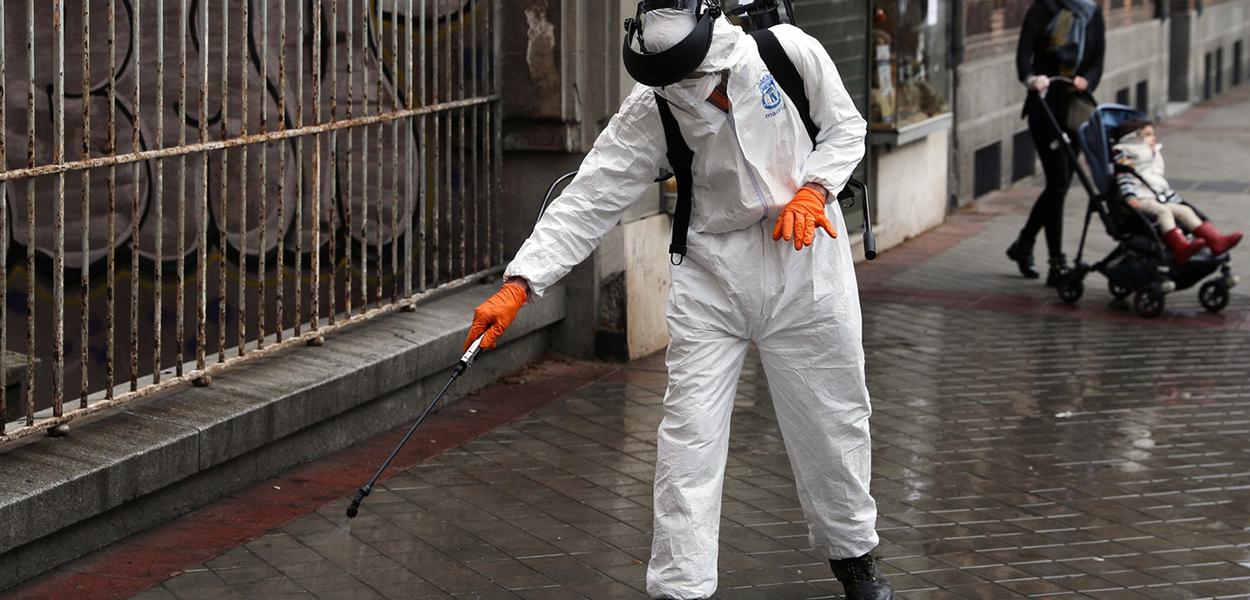 Homem desinfeta rua em Madri, Espanha (Foto: Susana Vera/Reuters) Homem desinfeta rua em Madri, Espanha