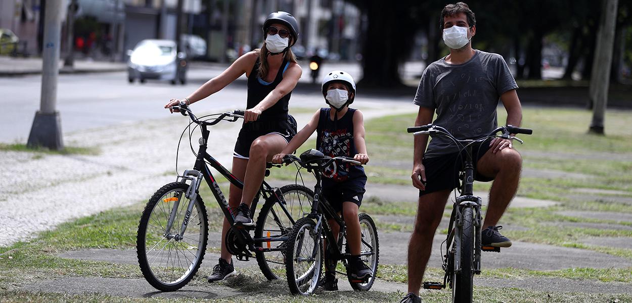 Família com máscara de proteção em praça (Foto: REUTERS/Pilar Olivares) Família com máscara de proteção em praça