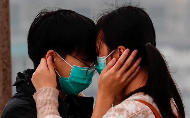 Casal utilizando máscaras (Foto: Tyrone Siu/Reuters) Casal utilizando máscaras