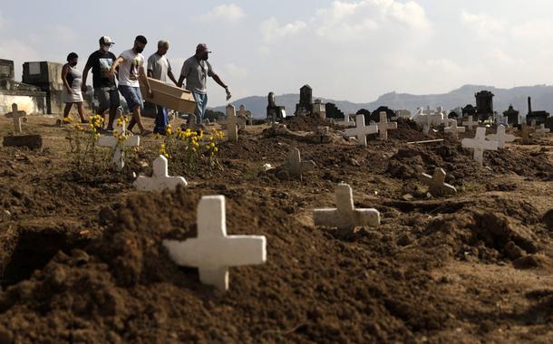 Marcos Vinicius Andrade da Silva, 26, ajuda a carregar no Cemitério de Inhauma o caixão de Valnir Mendes da Silva, 62, que morreu em uma calçada na favela Arará após dificuldades para respirar, em meio à pandemia do novo coronavírus. Rio de Janeiro, Brasil, 18/05/2020. (Foto: REUTERS/Ricardo Moraes) Marcos Vinicius Andrade da Silva, 26, ajuda a carregar no Cemitério de Inhauma o caixão de Valnir Mendes da Silva, 62, que morreu em uma calçada na favela Arará após dificuldades para respirar, em meio à pandemia do novo coronavírus. Rio de Janeiro, Brasil, 18/05/2020.