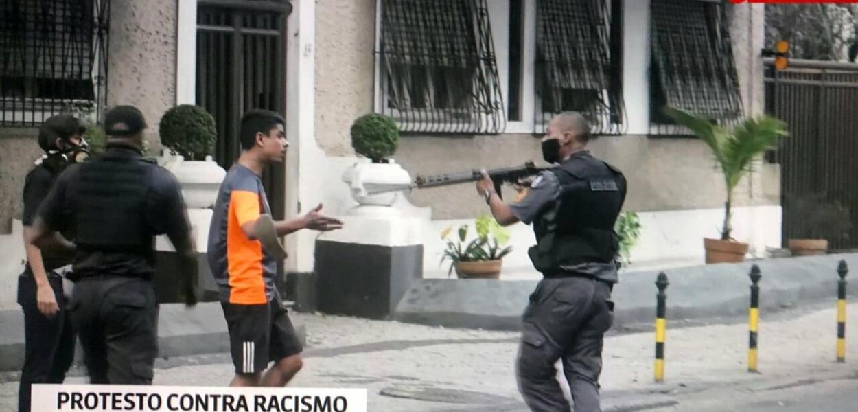 Policial aponta fuzil para jovem desarmado no Rio de Janeiro (Foto: Reprodução) Policial aponta fuzil para jovem desarmado no Rio de Janeiro