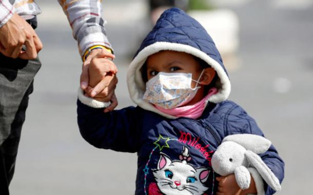 Criança usando máscara (Foto: Remo Casilli/Reuters) Criança usando máscara