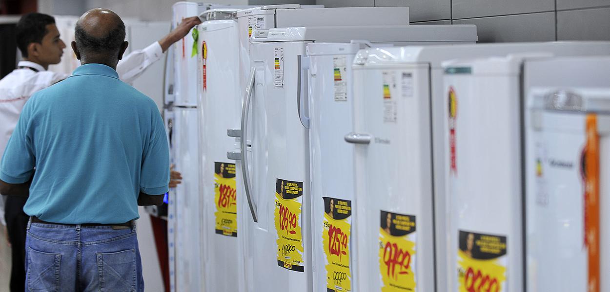 Vendedor mostra a cliente geladeiras da linha branca (Foto: FABIO RODRIGUES-POZZEBOM/ABR) Vendedor mostra a cliente geladeiras da linha branca