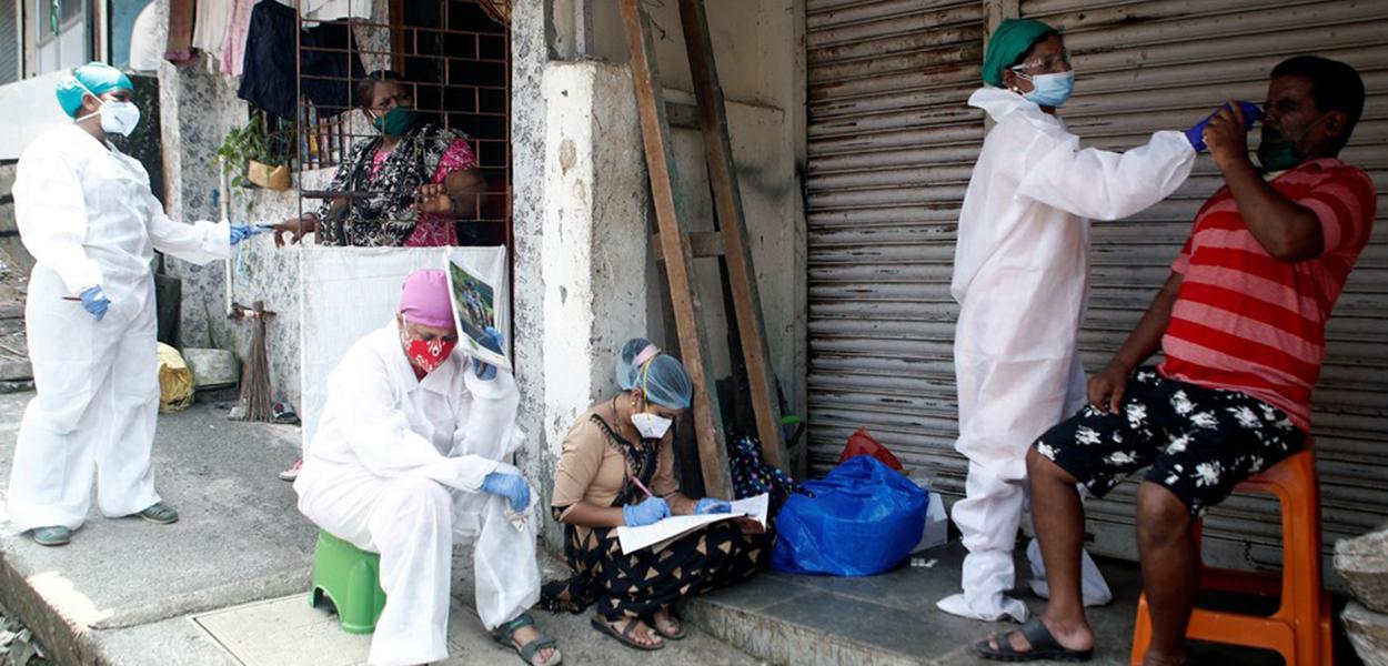 Profissionais da saúde recolhem material para testes de Covid-19 nas ruas de Mumbai, na Índia (Foto: Francis Mascarenhas/Reuters) Profissionais da saúde recolhem material para testes de Covid-19 nas ruas de Mumbai, na Índia
