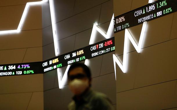 Homem usando máscara de proteção passa próximo de painel com cotações do mercado financeiro. 8/9/2020 (Foto: REUTERS/Willy Kurniawan) Homem usando máscara de proteção passa próximo de painel com cotações do mercado financeiro. 8/9/2020