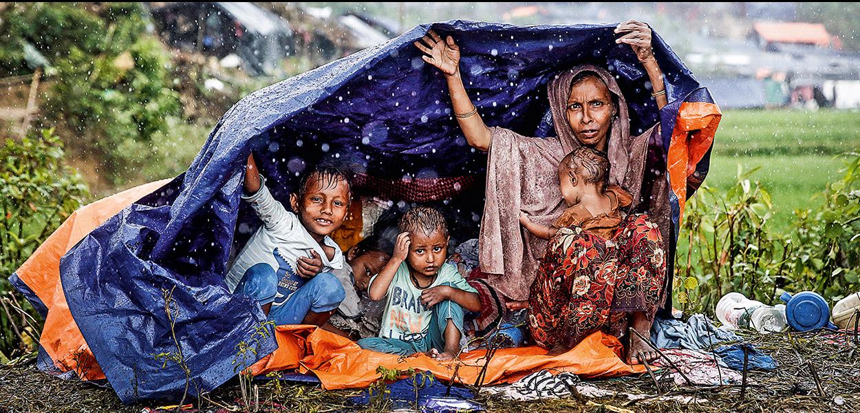 Família rohingya protege-se da chuva em Bangladesh, onde se refugiou: assassinatos e estupros contra muçulmanos de Mianmar - 30/08/2018 (Foto: Cathal McNaughton/Reuters) Família rohingya protege-se da chuva em Bangladesh, onde se refugiou: assassinatos e estupros contra muçulmanos de Mianmar - 30/08/2018