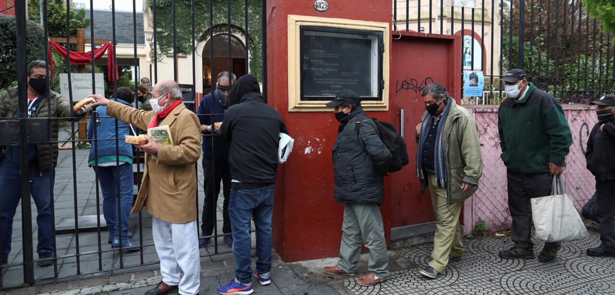 Pessoas fazem fila para obter ajuda de alimentação (Foto: Reuters) Pessoas fazem fila para obter ajuda de alimentação
