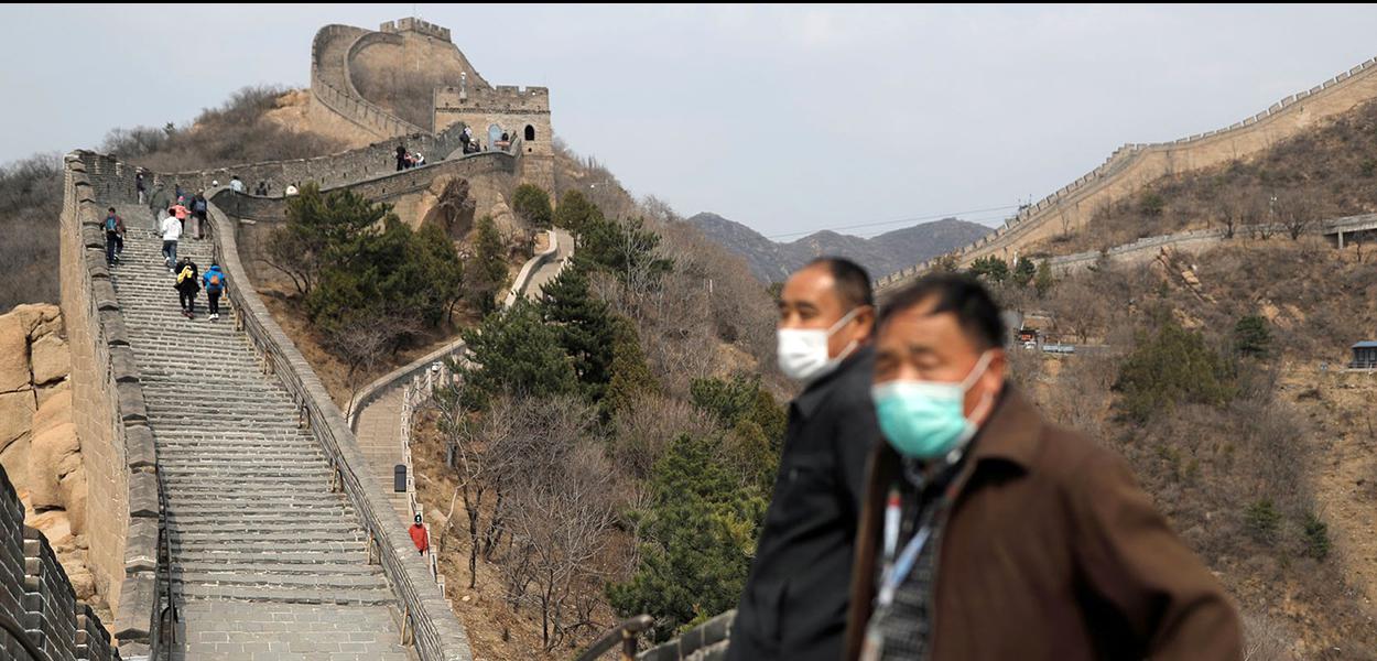 Mesmo de máscara, turistas já são vistos na Muralha da China. (Foto: Thomas Peter / Reuters) Mesmo de máscara, turistas já são vistos na Muralha da China.