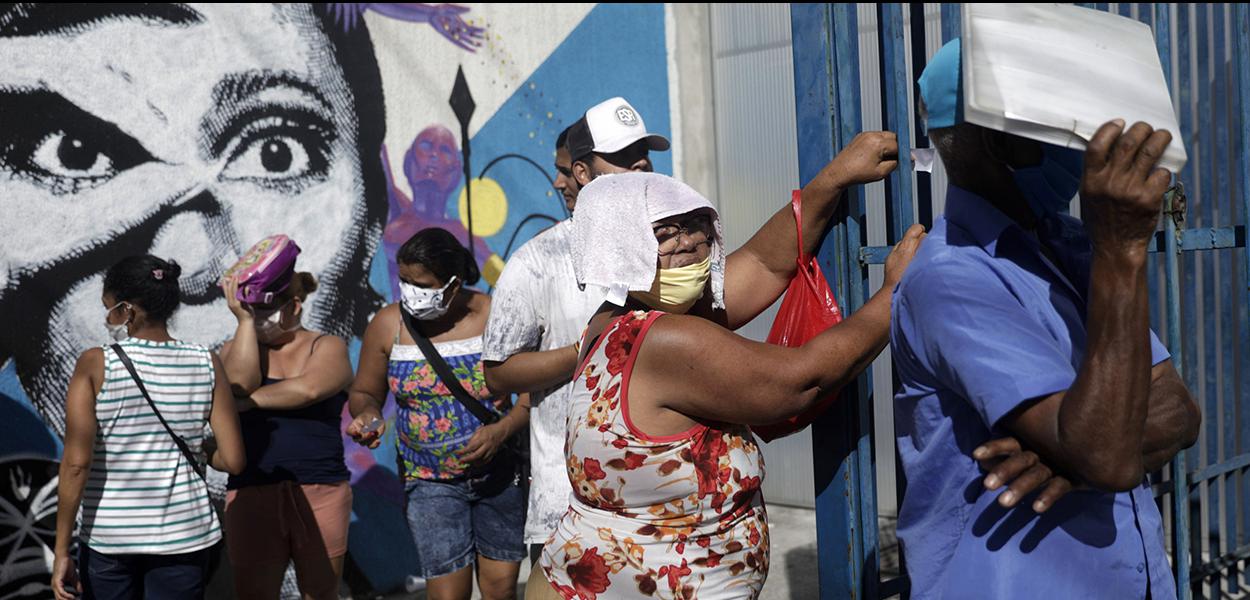 Pessoas esperam em fila do lado de fora de agência da Caixa para receber o auxílio emergencial do governo durante a pandemia. 27/04/2020 (Foto: REUTERS/Ricardo Moraes) Pessoas esperam em fila do lado de fora de agência da Caixa para receber o auxílio emergencial do governo durante a pandemia. 27/04/2020