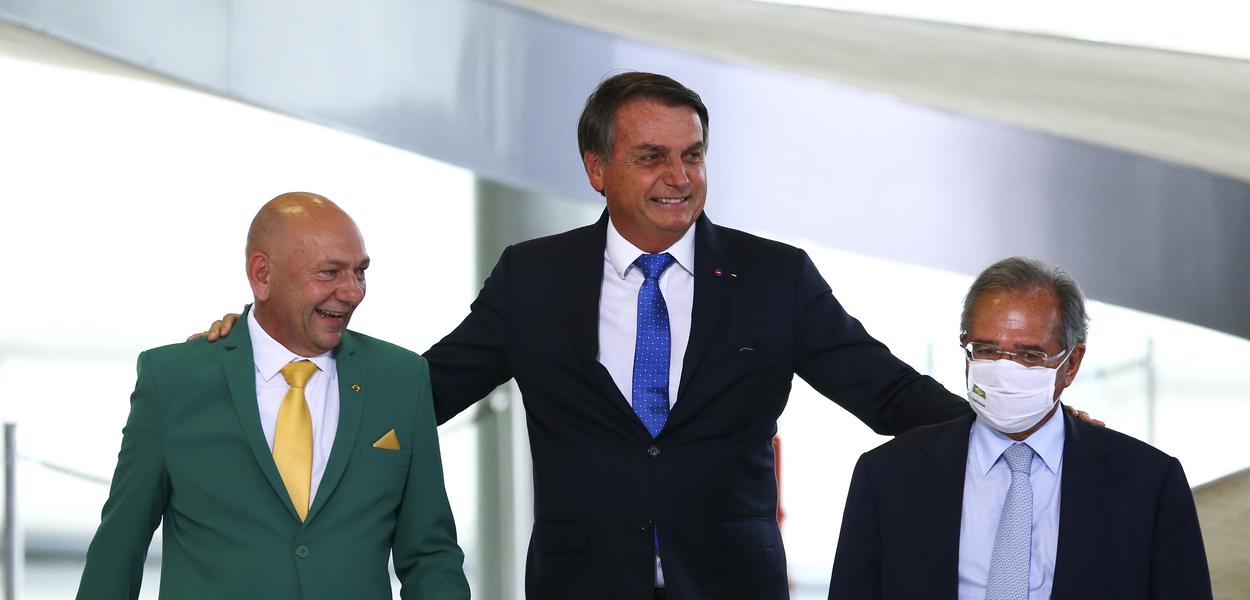 O empresário Luciano Hang, Jair Bolsonaro e o ministro da Economia, Paulo Guedes, durante o lançamento do programa Voo Simples, no Palácio do Planalto. (Foto: Marcelo Camargo/Agência Brasil) O empresário Luciano Hang, Jair Bolsonaro e o ministro da Economia, Paulo Guedes, durante o lançamento do programa Voo Simples, no Palácio do Planalto.