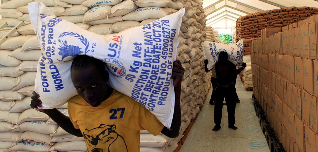 Pessoas carregam sacos de alimentos do Programa Mundial de Alimentos da ONU em assentamento para refugiados do Sudão do Sul em Uganda (Foto: REUTERS/James Akena) Pessoas carregam sacos de alimentos do Programa Mundial de Alimentos da ONU em assentamento para refugiados do Sudão do Sul em Uganda