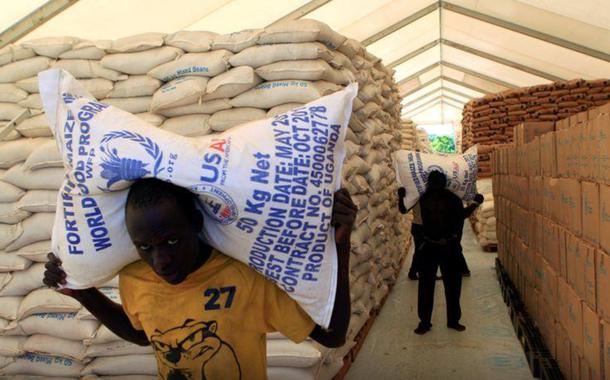 Pessoas carregam sacos de alimentos do Programa Mundial de Alimentos da ONU em assentamento para refugiados do Sudão do Sul em Uganda (Foto: REUTERS/James Akena) Pessoas carregam sacos de alimentos do Programa Mundial de Alimentos da ONU em assentamento para refugiados do Sudão do Sul em Uganda