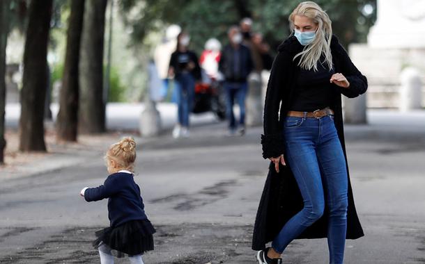 Mulher usando máscara brinca com criança em Roma (Foto: REUTERS/Yara Nardi) Mulher usando máscara brinca com criança em Roma