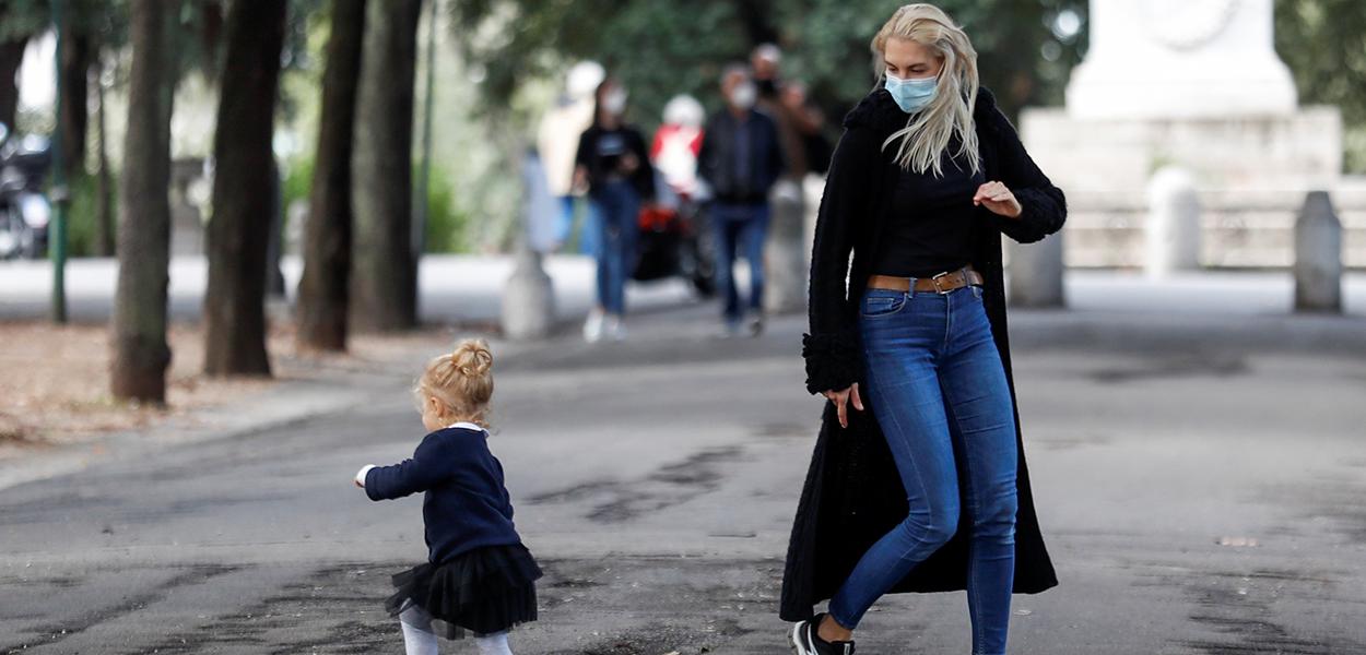 Mulher usando máscara brinca com criança em Roma (Foto: REUTERS/Yara Nardi) Mulher usando máscara brinca com criança em Roma