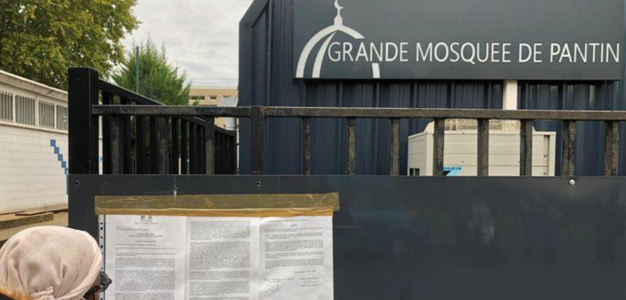 Mulher lê decreto na entrada da Grande Mesquista de Pantin (Foto: REUTERS/Antony Paone) Mulher lê decreto na entrada da Grande Mesquista de Pantin