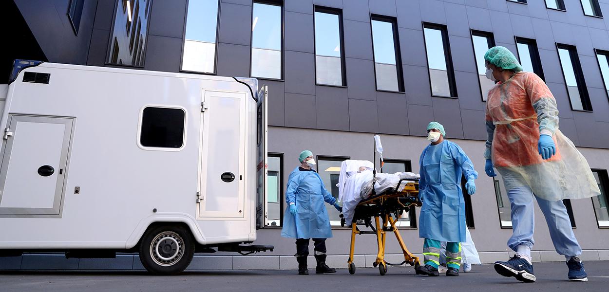 Vista externa de profissionais de saúde atendendo paciente infectado por Covid-19 em Liege, Bélgica. 23/3/2020. (Foto: REUTERS/Yves Herman) Vista externa de profissionais de saúde atendendo paciente infectado por Covid-19 em Liege, Bélgica. 23/3/2020.
