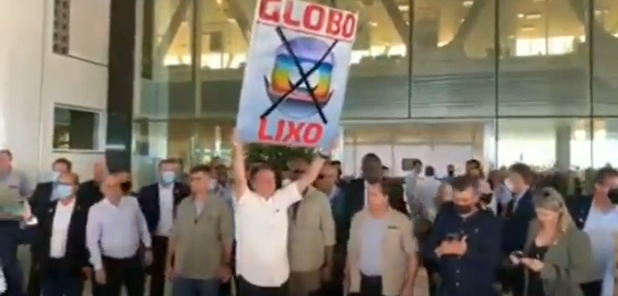 Bolsonaro ergue cartaz com mensagem "Globo lixo" (Foto: Reprodução) Bolsonaro ergue cartaz com mensagem "Globo lixo"
