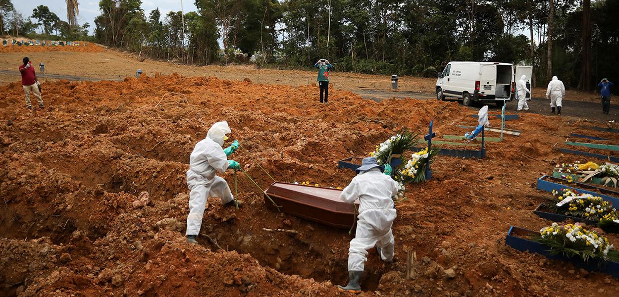 Coveiros vestindo roupas de proteção se preparam para enterrar no cemitério Parque Taruma, em Manaus. (Foto: Bruno Kelly/Reuters) Coveiros vestindo roupas de proteção se preparam para enterrar no cemitério Parque Taruma, em Manaus.