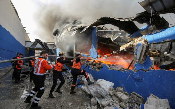 Bombeiros palestinos apagam chamas de fábrica atingida por míssil de Israel (Foto: REUTERS/Ashraf Abu Amrah) Bombeiros palestinos apagam chamas de fábrica atingida por míssil de Israel