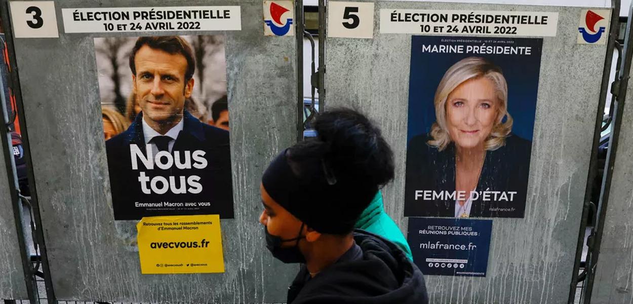 Pedestre passa por cartazes de Emmanuel Macron e Marine Le Pen em 4 de abril de 2022 (Foto: Gonzalo Fuentes/Reuters) www.brasil247.com - Pedestre passa por cartazes de Emmanuel Macron e Marine Le Pen em 4 de abril de 2022