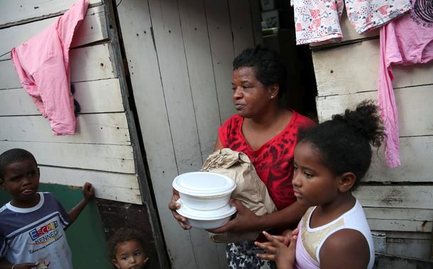 Residentes de uma comunidade no Rio de Janeiro recebem comida de voluntários em 2021 (Foto: REUTERS/Ricardo Moraes) Residentes de uma comunidade no Rio de Janeiro recebem comida de voluntários em 2021