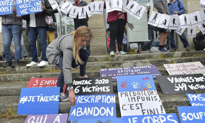<p>Ljudi postavljaju plakate tokom demonstracija uoči izricanja presude na suđenju Žoelu Le Skuarnjeku, 74-godišnjem bivšem hirurgu optuženom za silovanje i seksualno zlostavljanje 299 djece, u srijedu, 28. maja 2025. godine u Vanu, Bretanja, zapadna Francuska</p>