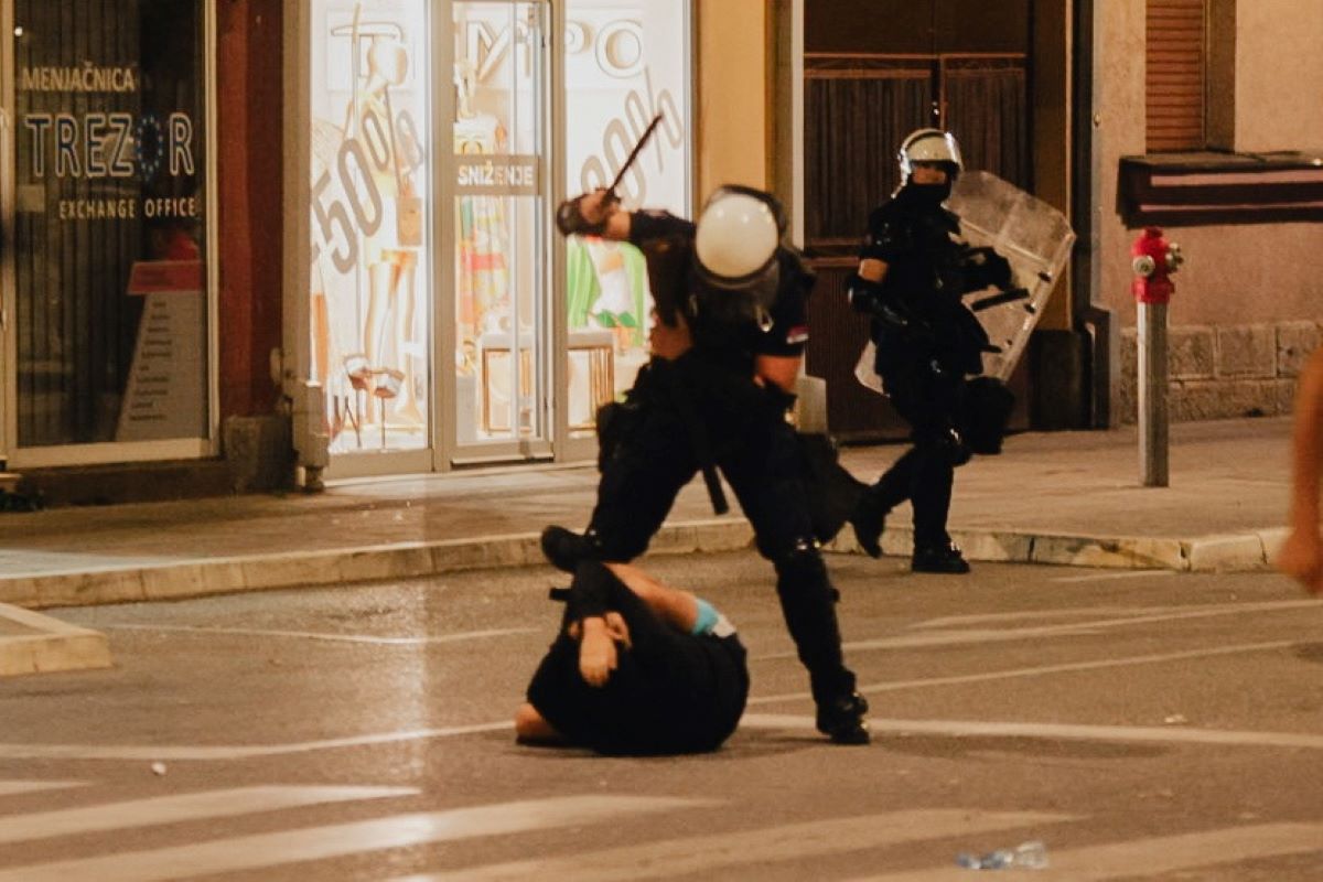 Policajac tuče mladića koji leži na ulici (Foto: Đorđe Đoković)