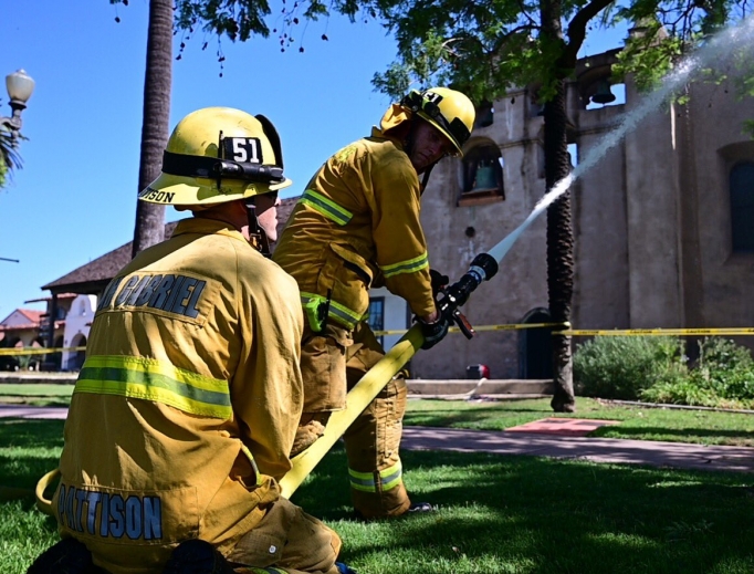 Firefighters try to extinguish a rooftop fire at San Gabriel Mission. Firefighters try to extinguish a rooftop fire at San Gabriel Mission.