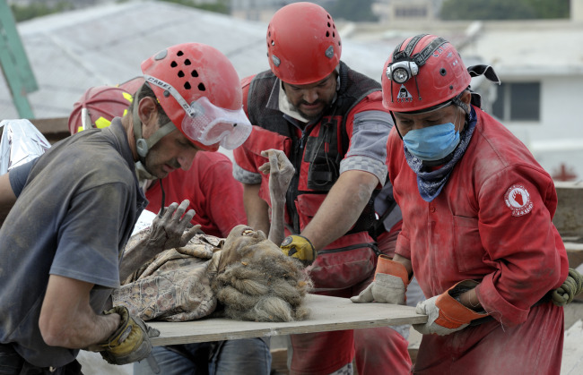 Members of a Mexican search-and-rescue team pull Anna Zizi alive Jan. 19 from the rubble in Port-au-Prince, Haiti, after the devastating Jan. 12 earthquake. She was rescued from the collapsed home of the parish priest at the Cathedral of Our Lady of the Assumption. Several of of the rescue workers were in tears as they pulled the woman free from tons of rubble.
Members of a Mexican search-and-rescue team pull Anna Zizi alive Jan. 19 from the rubble in Port-au-Prince, Haiti, after the devastating Jan. 12 earthquake. She was rescued from the collapsed home of the parish priest at the Cathedral of Our Lady of the Assumption. Several of of the rescue workers were in tears as they pulled the woman free from tons of rubble.