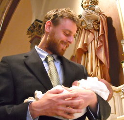 Eddie Gaven holds newly baptized son while St. Joseph looks on. Eddie Gaven holds newly baptized son while St. Joseph looks on.