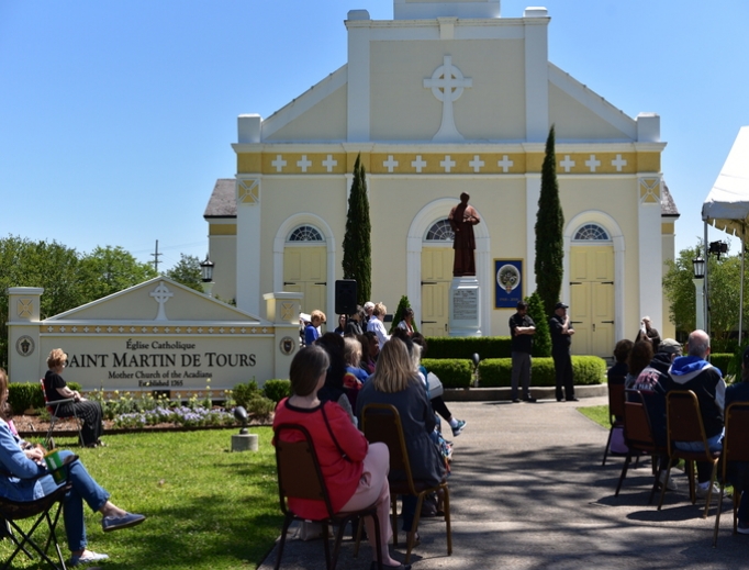 Bible 'hearers' listen to the marathon with St. Martin de Tours Church in the background. Below, laity, clergy and religious turned out to listen in the town square. Bibles in various languages spoken in the Diocese of Lafayette are displayed on the head table.
Bible 'hearers' listen to the marathon with St. Martin de Tours Church in the background. Below, laity, clergy and religious turned out to listen in the town square. Bibles in various languages spoken in the Diocese of Lafayette are displayed on the head table.
