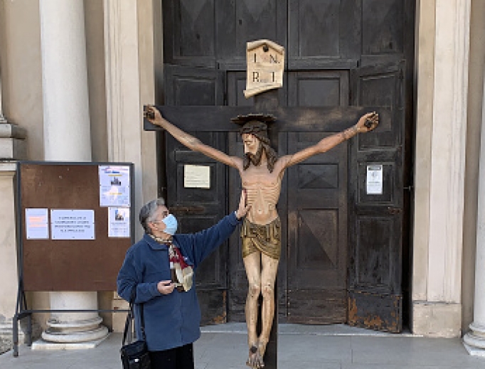 A woman wearing a protective mask touches the crucifix outside the village church on March 16 in Brescello, Italy. The Italian government continues to enforce nationwide lockdown measures to control the coronavirus spread. A woman wearing a protective mask touches the crucifix outside the village church on March 16 in Brescello, Italy. The Italian government continues to enforce nationwide lockdown measures to control the coronavirus spread.