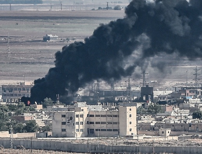 This picture, taken Oct. 13, from the Turkish city of Ceylanpinar shows smoke rising from the Syrian border town of Ras al-Ain as fighting rages along the border on the fifth day of a Turkish offensive in Syria against the Kurdish People's Protection Units (YPG) that has provoked an international outcry and left dozens of civilians and fighters dead. This picture, taken Oct. 13, from the Turkish city of Ceylanpinar shows smoke rising from the Syrian border town of Ras al-Ain as fighting rages along the border on the fifth day of a Turkish offensive in Syria against the Kurdish People's Protection Units (YPG) that has provoked an international outcry and left dozens of civilians and fighters dead.
