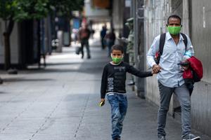 Father and son holding hands wearing face masks walk the streets during the quarantine decreed by Nicolas Maduro in Caracas, Venezuela, March 24, 2020. Father and son holding hands wearing face masks walk the streets during the quarantine decreed by Nicolas Maduro in Caracas, Venezuela, March 24, 2020.