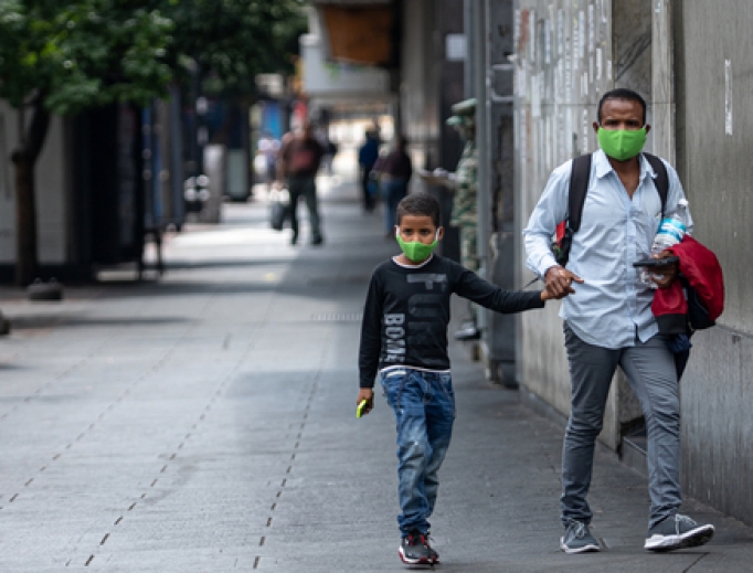 Father and son holding hands wearing face masks walk the streets during the quarantine decreed by Nicolas Maduro in Caracas, Venezuela, March 24, 2020. Father and son holding hands wearing face masks walk the streets during the quarantine decreed by Nicolas Maduro in Caracas, Venezuela, March 24, 2020.