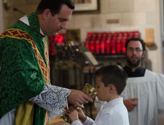 Above, Bishop Steven Lopes provides the Precious Blood at first Communion for St. Alban’s Catholic Church, an ordinariate parish in Rochester, N.Y. Below, children receive first Communion at St. Joseph Oratory in Detroit. Above, Bishop Steven Lopes provides the Precious Blood at first Communion for St. Alban’s Catholic Church, an ordinariate parish in Rochester, N.Y. Below, children receive first Communion at St. Joseph Oratory in Detroit.