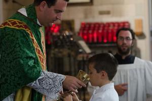Above, Bishop Steven Lopes provides the Precious Blood at first Communion for St. Alban’s Catholic Church, an ordinariate parish in Rochester, N.Y. Below, children receive first Communion at St. Joseph Oratory in Detroit. Above, Bishop Steven Lopes provides the Precious Blood at first Communion for St. Alban’s Catholic Church, an ordinariate parish in Rochester, N.Y. Below, children receive first Communion at St. Joseph Oratory in Detroit.
