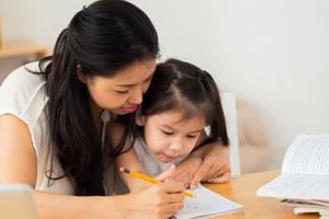 Mother teaching her young daughter how to write. Mother teaching her young daughter how to write.