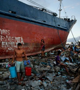 Residents carry water Nov. 18 past a ship that was thrown into the street by Typhoon Haiyan in Tacloban, Philippines. Residents carry water Nov. 18 past a ship that was thrown into the street by Typhoon Haiyan in Tacloban, Philippines.