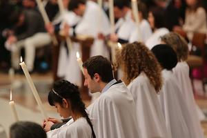WELCOME HOME! Catechumens receive candles at the Easter vigil Mass before receiving the sacraments in St. Peter's Basilica.
WELCOME HOME! Catechumens receive candles at the Easter vigil Mass before receiving the sacraments in St. Peter's Basilica.
