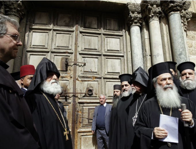 Greek Orthodox Patriarch of the Holy Land Theophilos III, second right, stands outside the closed doors of the Church of the Holy Sepulcher, traditionally believed by many Christians to be the site of the crucifixion and burial of Jesus Christ, in Jerusalem, Feb. 25. The leaders of the major Christian sects in Jerusalem closed the Church of the Holy Sepulcher for several hours on Sunday to protest an Israeli plan to tax their properties. Greek Orthodox Patriarch of the Holy Land Theophilos III, second right, stands outside the closed doors of the Church of the Holy Sepulcher, traditionally believed by many Christians to be the site of the crucifixion and burial of Jesus Christ, in Jerusalem, Feb. 25. The leaders of the major Christian sects in Jerusalem closed the Church of the Holy Sepulcher for several hours on Sunday to protest an Israeli plan to tax their properties.