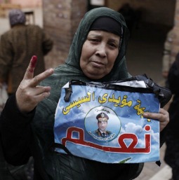 A woman shows her ink-stained fingers, evidence she has voted in Egypt's constitutional referendum, and holds a poster of General Abdel Fattah al-Sisi at a Cairo polling booth on Jan. 14. A woman shows her ink-stained fingers, evidence she has voted in Egypt's constitutional referendum, and holds a poster of General Abdel Fattah al-Sisi at a Cairo polling booth on Jan. 14.